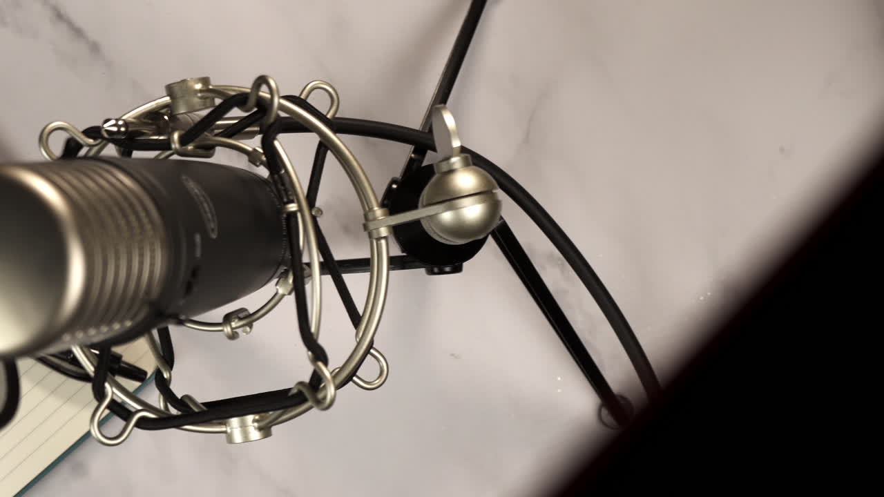 Overhead View of Microphone, Notebook, and Pen on Desk