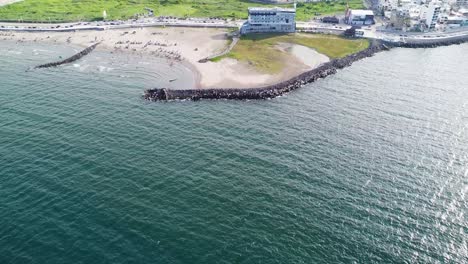 Aerial-drone-tilt-up-shot-over-the-coast-of-Veracruz-with-highway-net-to-the-tropical-beach-in-Veracruz-port-city,-Veracruz,-Mexico-at-daytime