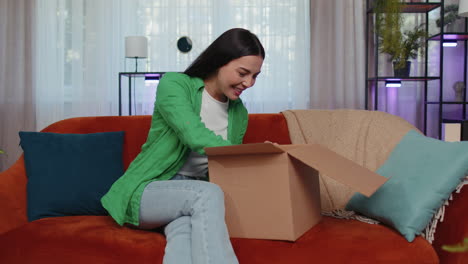 feliz joven compradora desempaque de caja de cartón entrega de paquete compras en línea compra en casa