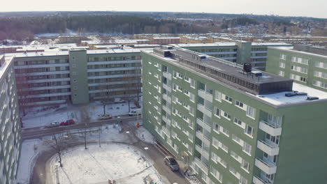 Vista-Aérea-Del-Suburbio-De-Estocolmo-Husby,-Casas-Verdes,-Drone-En-Invierno