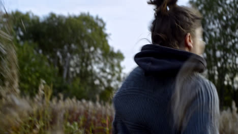 moving and dynamic frame with young and happy woman running through the meadow.