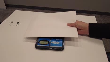 Weighing letter in an office to be mailed.