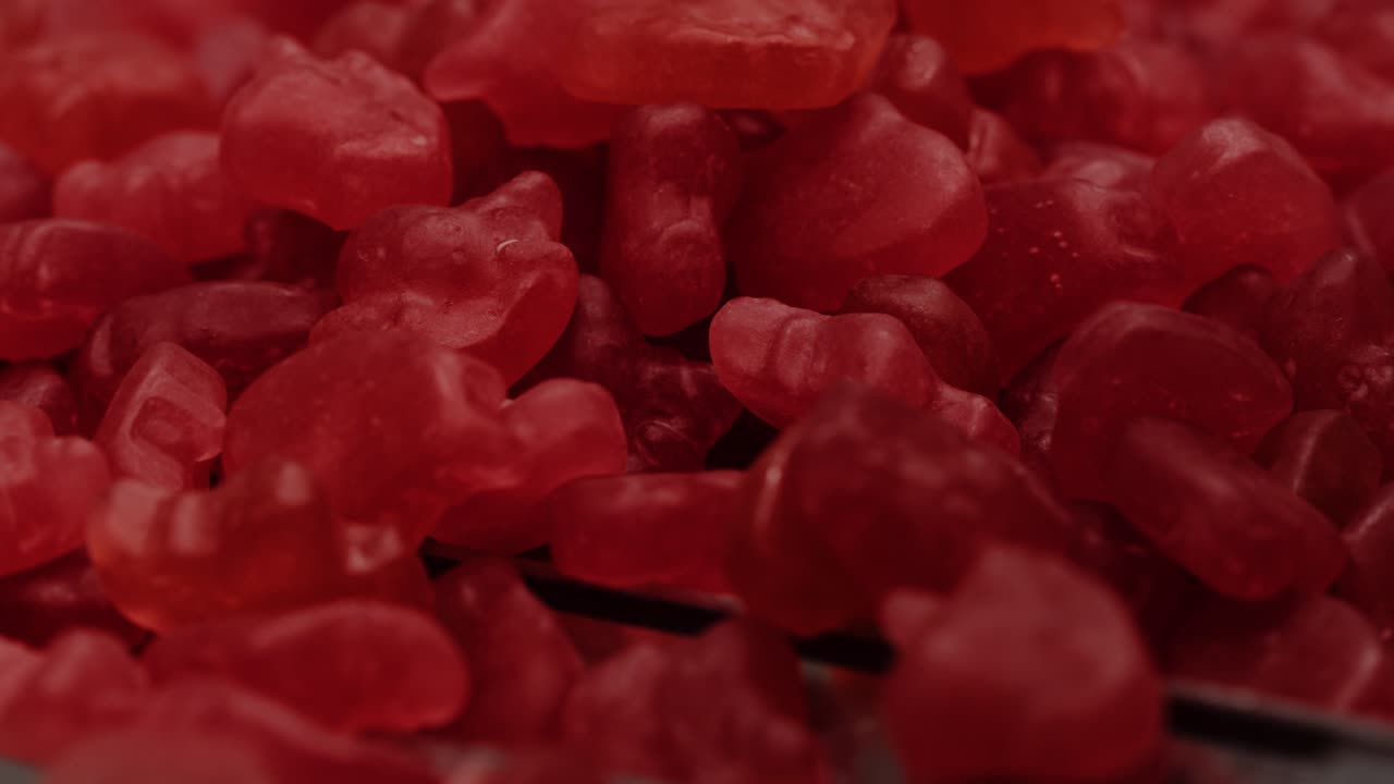 primer plano de vitaminas gomosas de gelatina roja en el proceso de producción nutracéutica