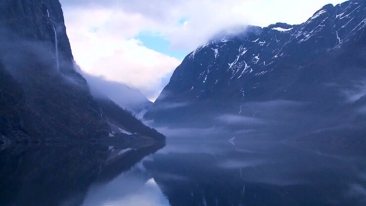 Nuvole e nebbia incombono su un fiordo in Norvegia in timelapse 2