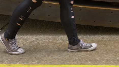 beat up shoes and outfit walking along the sidewalk of an industrial place