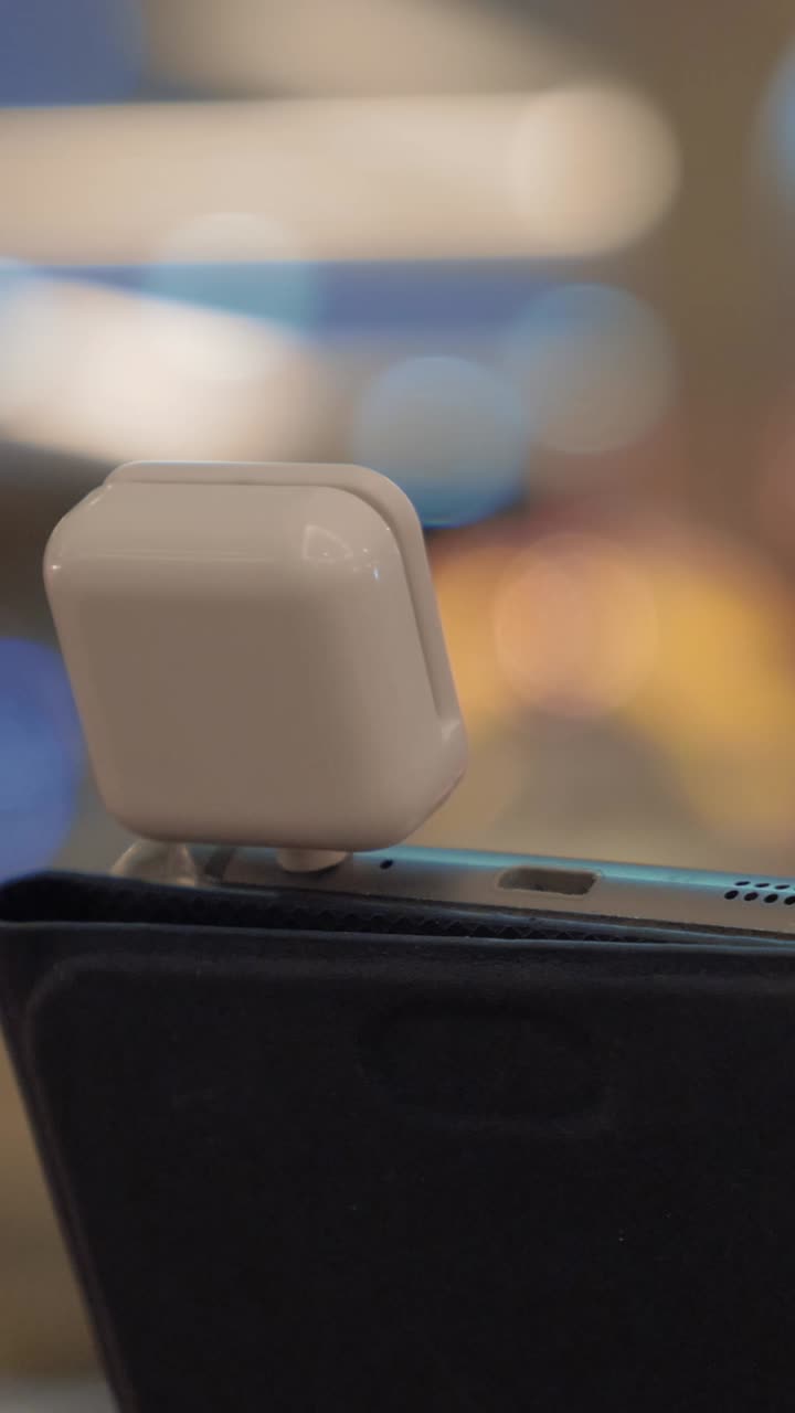 Primo piano di un piccolo dispositivo bianco collegato a uno smartphone