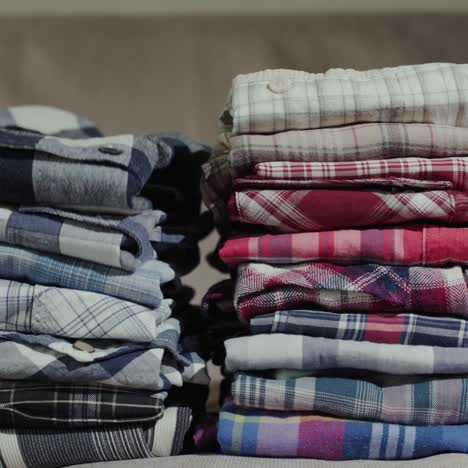 Women's-hands-put-men's-shirts-in-a-neat-pile