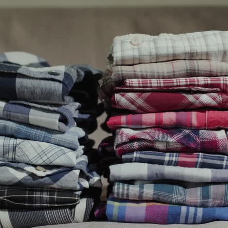 women's hands put men's shirts in a neat pile