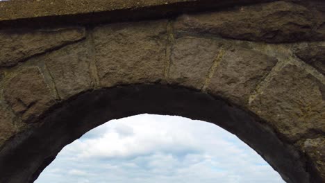 4k nice tilt down to reveal view of the columbia river through an archway with mostly cloudy sky