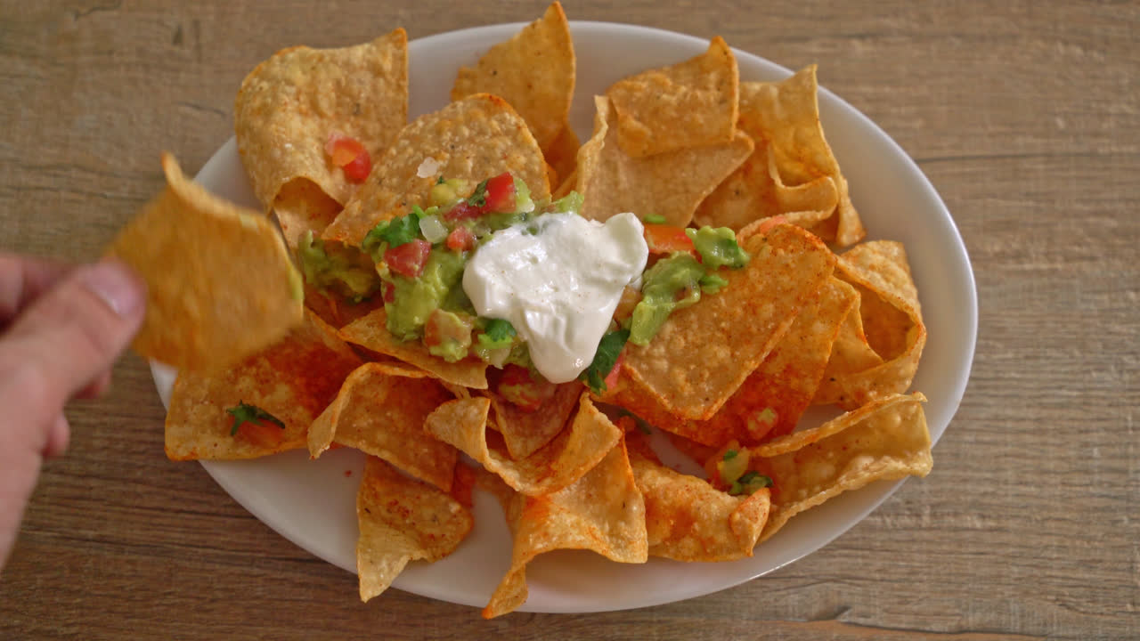 Chips de tortilla de nachos mexicanos con jalapeño, guacamole, salsa de tomate y salsa