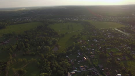 vista de las casas de campo del bosque contra el cielo azul con nubes en la puesta de sol en el verano de rusia