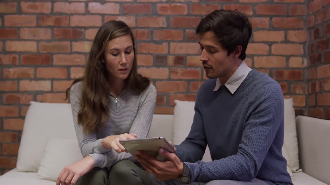 hombre de negocios creativo y mujer de negocios discutiendo sobre una mesa digital en una oficina moderna
