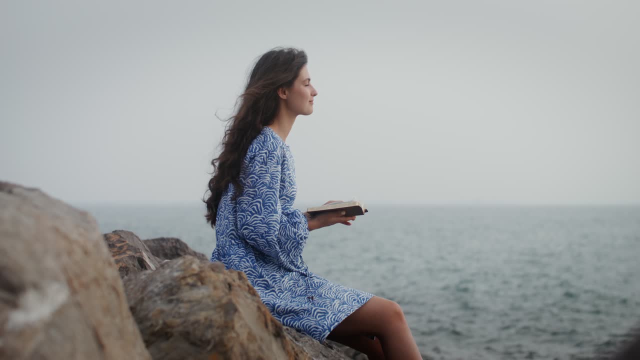 mujer leyendo junto al mar