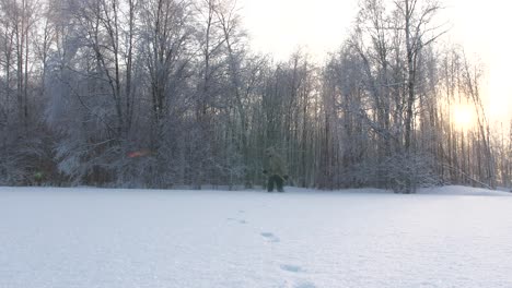 El-Hombre-Camina-A-Través-De-La-Nieve-Profunda-En-El-Bosque,-Vista-Lateral