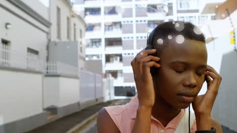 hermosa música afroamericana escuchando con auriculares en la calle en la ciudad