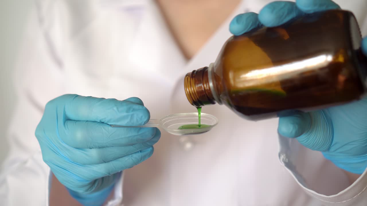 el médico vierte el medicamento en una cuchara