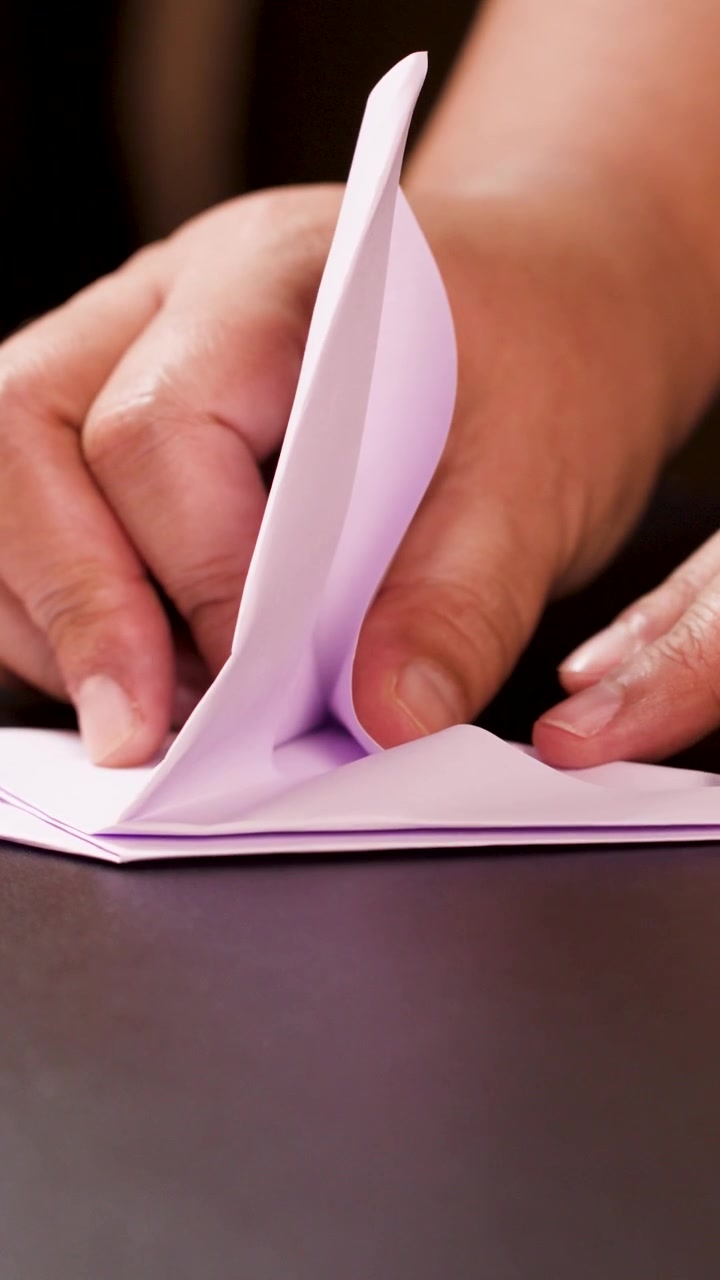 Close-up of Hands Folding Paper into Origami Shape