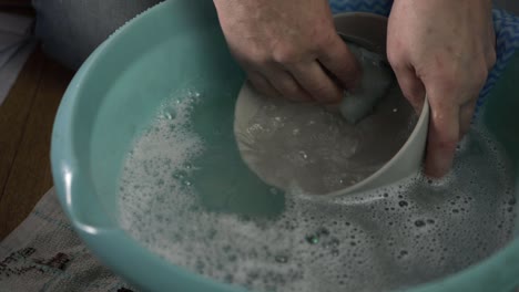 Hands-washing-dishes-with-soapy-water-medium-shot