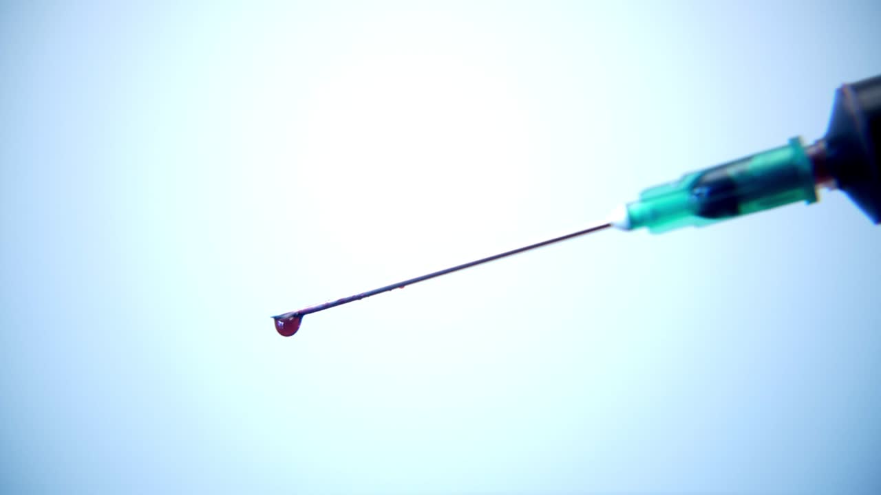 Gota de Sangue Pingando da Ponta da Agulha da Seringa