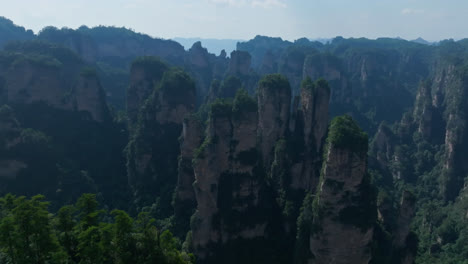 drone flying over rocky mountain pillars, summer day in zhangjiajie, china