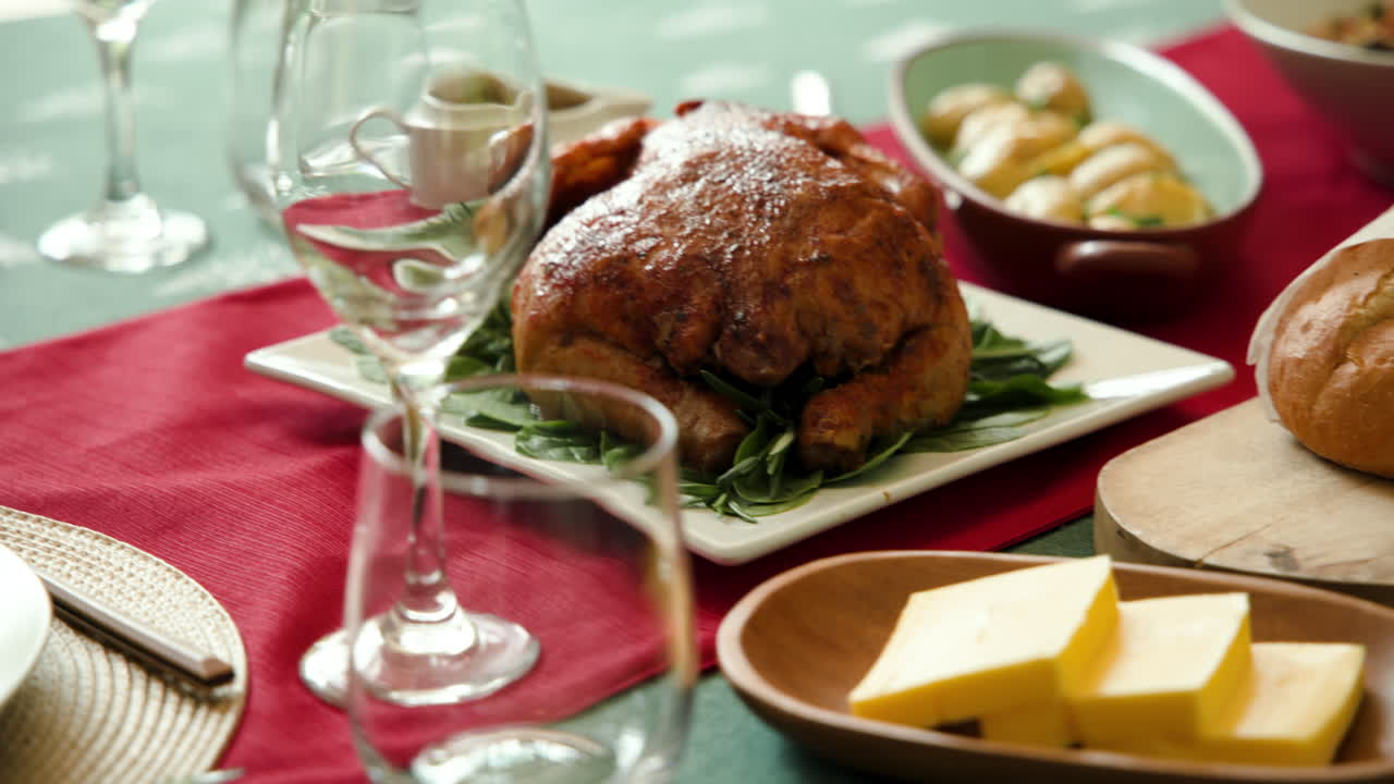 Festive holiday table setting with roasted chicken and wine glasses