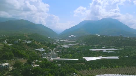 vista aérea de una ciudad de valle de montaña con granjas y invernaderos