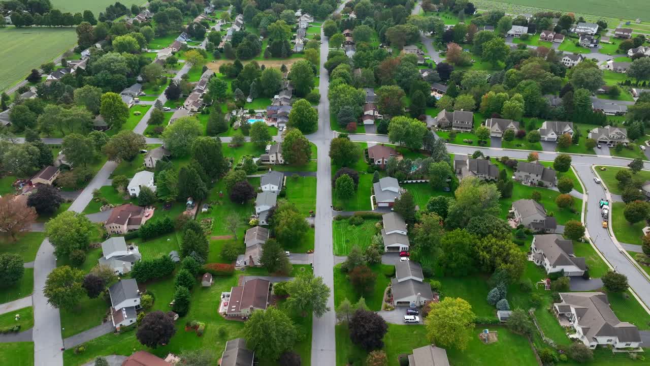vista aérea de un vecindario suburbano exuberante y verde con carreteras sinuosas