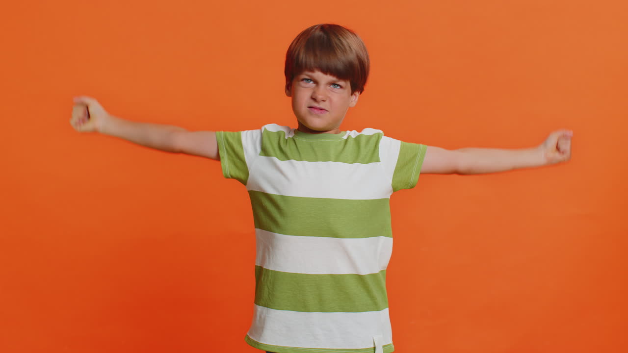 Fit sporty child boy kid showing biceps and looking healthy feeling power strength success win