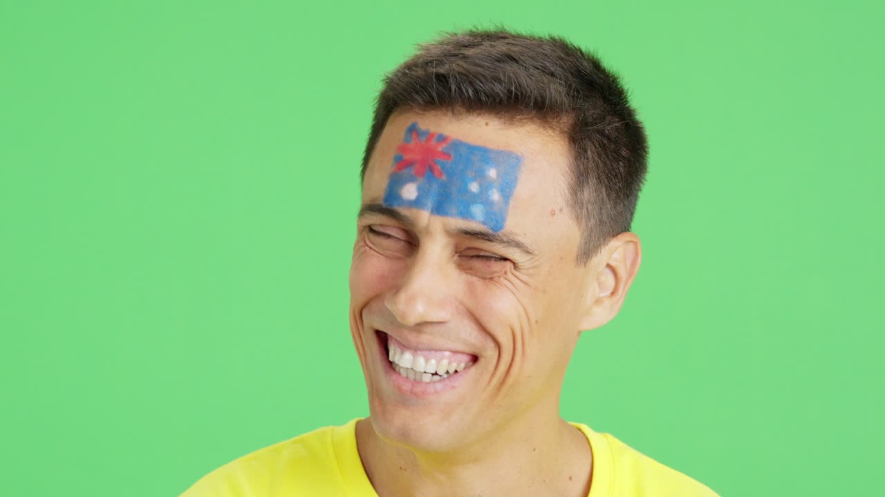 Man with a australian flag painted on the face smiling
