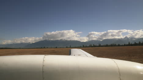 plane travelling along the tarmac runway of a small mountain airport