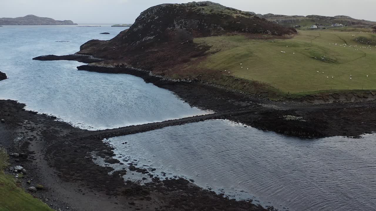 Aerial shot flying over a causeway to St Columba's island on the Hebrides