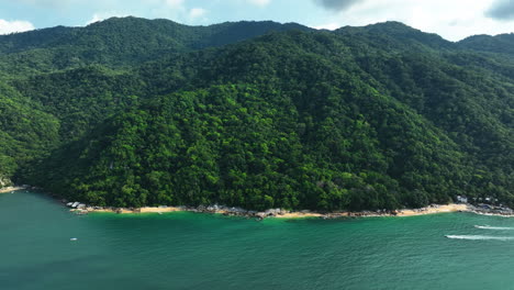 Aerial-tracking-shot-of-the-mountainous-coastline-jungle-of-Puerto-Vallarta,-Mexico