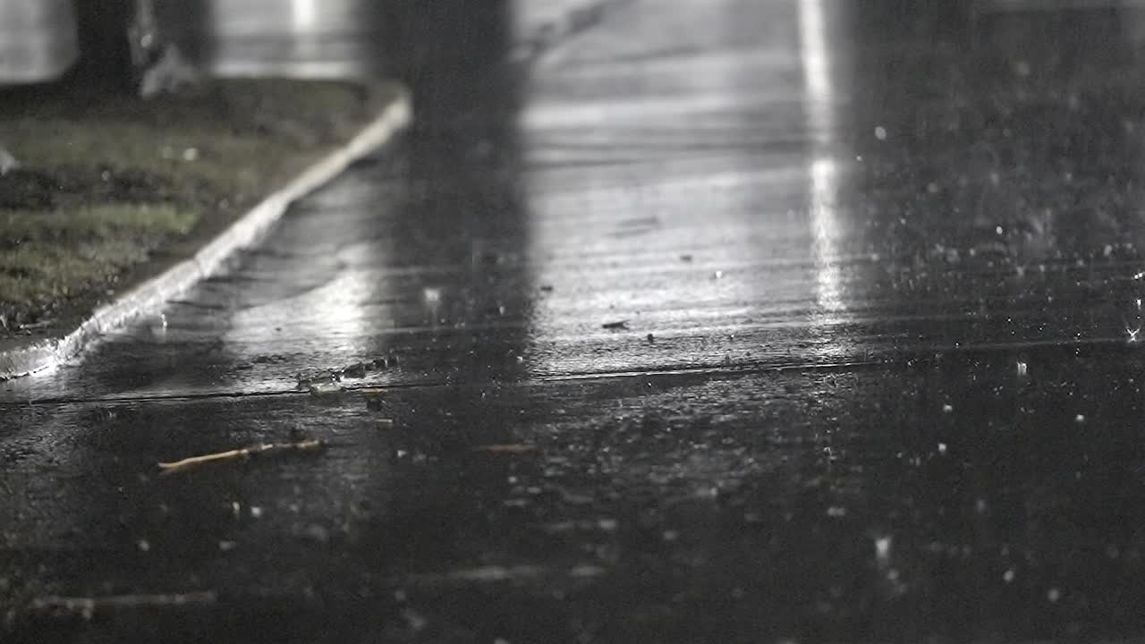 Slow Motion Raindrops Falling on Wet Pavement, Reflecting Lights