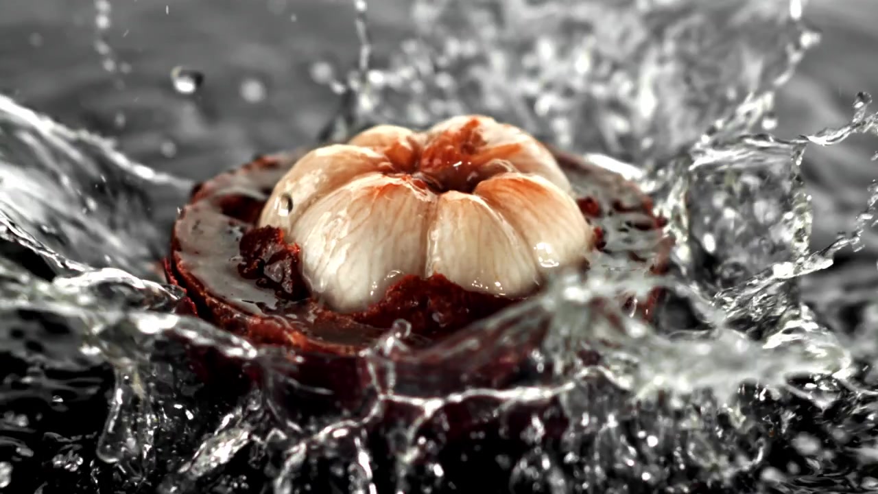 Frutto di mangostano fresco che si tuffa nell'acqua al rallentatore