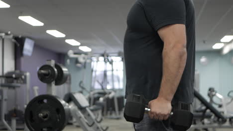 el hombre realiza flexiones de bíceps de pie. levantarse