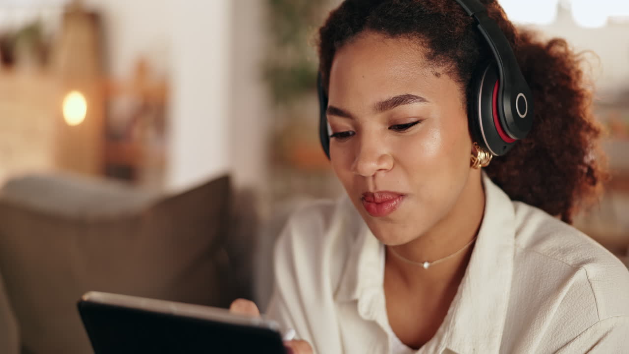 Woman using tablet and headphones in a home environment