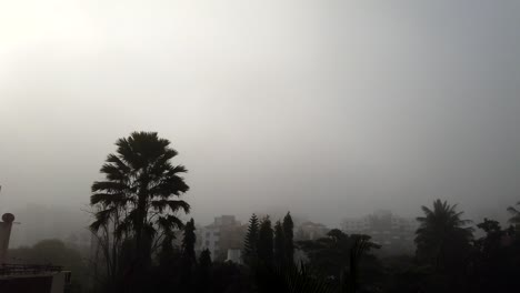 Zeitraffer-Des-Nebels-Bei-Winterwetter-Kurz-Nach-Sonnenaufgang-Mit-Blauem-Himmel-Darüber,-Während-Die-Stadt-Vom-Nebel-Bedeckt-Ist---Coronavirus