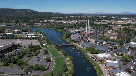 people floating on the river on inner tubes through a small town