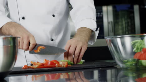 Chef-cooking-vegetables-at-kitchen.-Closeup-hands-cutting-organic-food