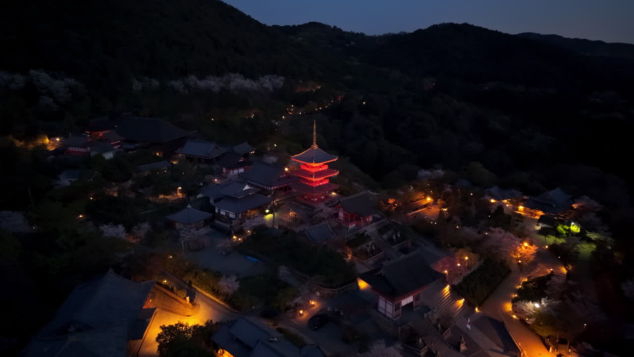 Aerial drone view of the illuminated Kiyomizu-dera temple in the evening
