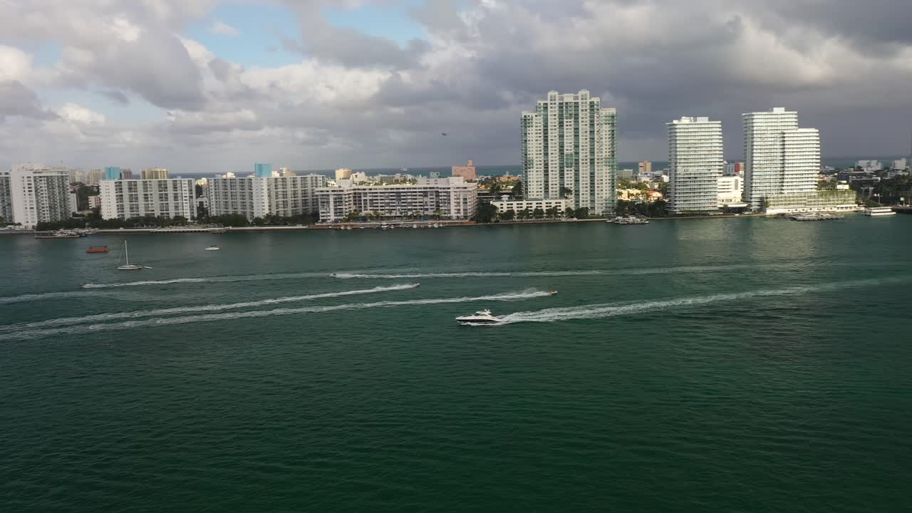 imágenes de drones del centro de miami con lanchas rápidas en el agua con edificios en segundo plano
