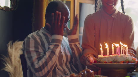 joyous african american man celebrating birthday with family