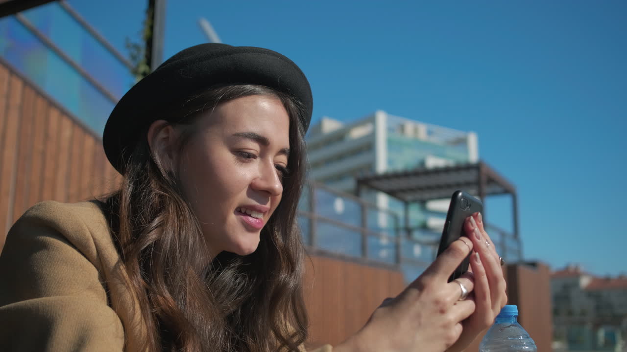 Donna che per mezzo del telefono all'aperto