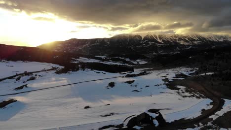 Drone-shot-of-an-amazing-sunset-over-the-mountains-during-winter