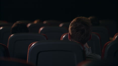 back view of people sitting in seats in the cinema