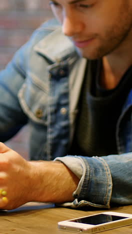 hombre usando una tableta digital con un vaso de jugo en la mesa