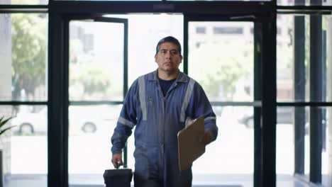 employee in uniform carefully reviews documents while entering a brightly lit office building, showcasing professionalism and attention to detail