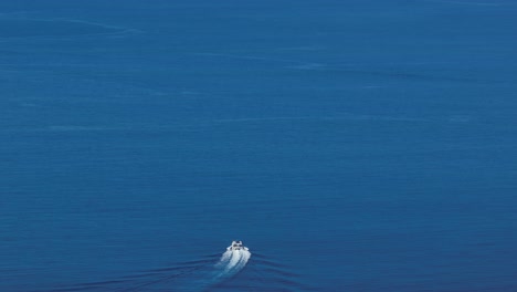 boat in blue ocean waters leaving a large wake