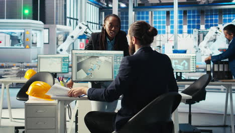 photovoltaics factory manager looking over schematics, instructing worker