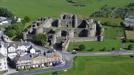 Sonnige-Touristische-Beaumaris-Schlossstadt-Luftaufnahme-Alte-Anglesey-Festung-Wahrzeichen-Langsam-Zurückziehen